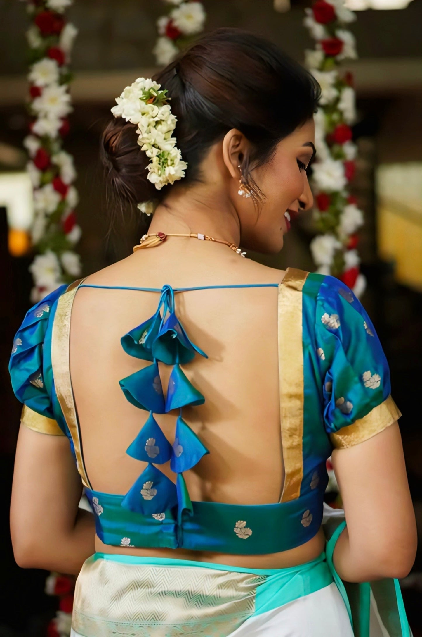 Blue silk blouse with open back and layered tassel bow design, perfect for traditional sarees.