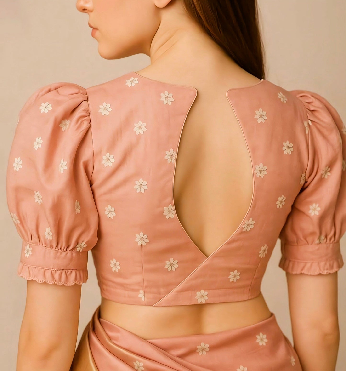 Peach floral embroidered puff-sleeve blouse with deep V-back neck design, perfect for modern saree and festive wear.