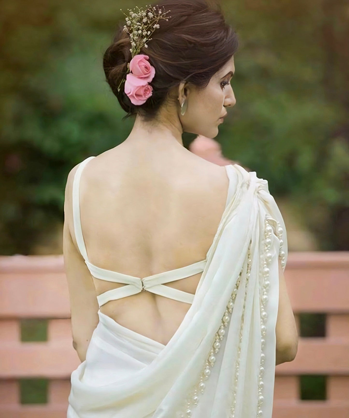White saree blouse with elegant minimal cross-strap back design and pearl-embellished pallu