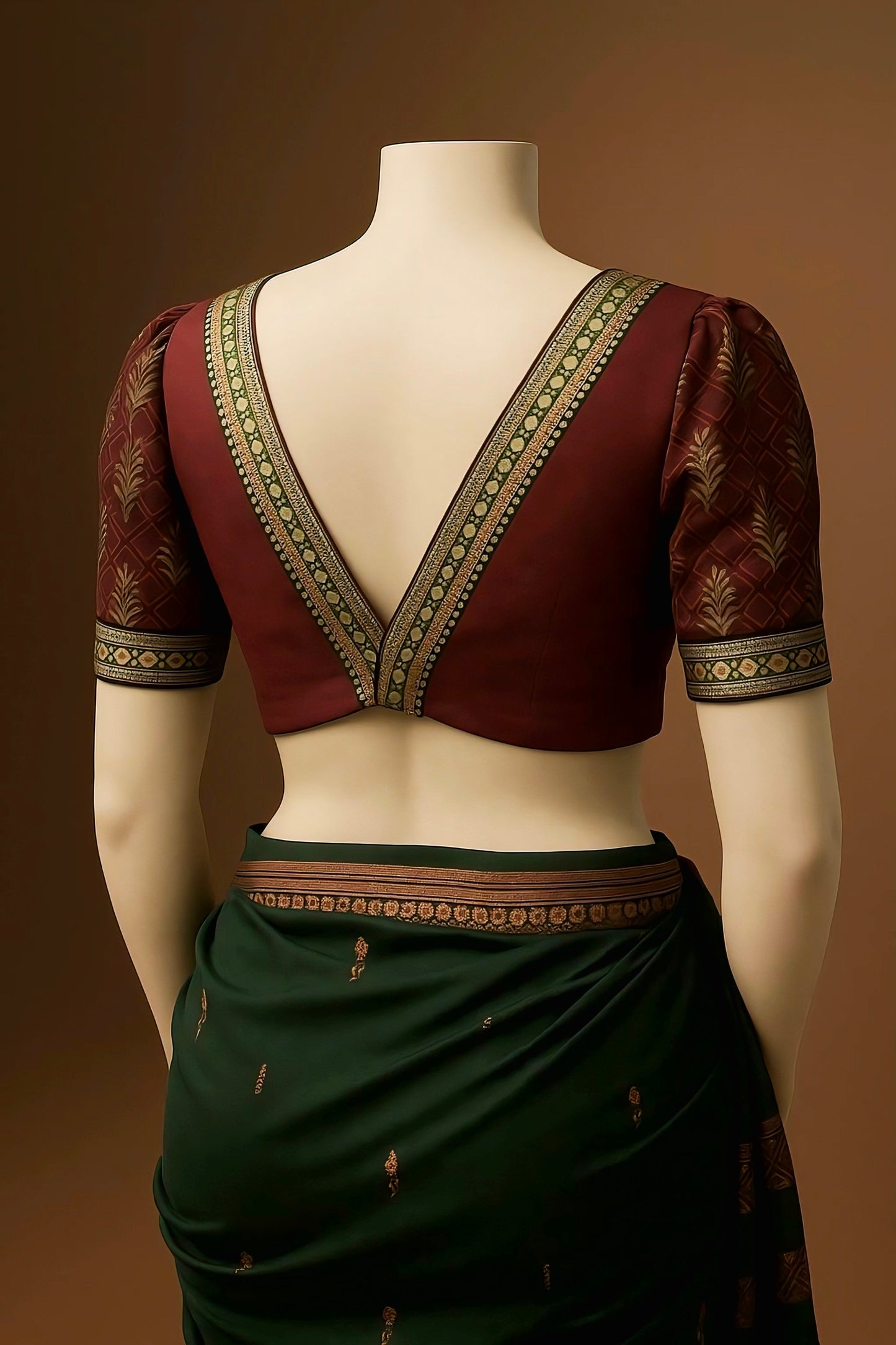 Maroon silk deep V-back blouse with gold and green zari border and designer sleeves.