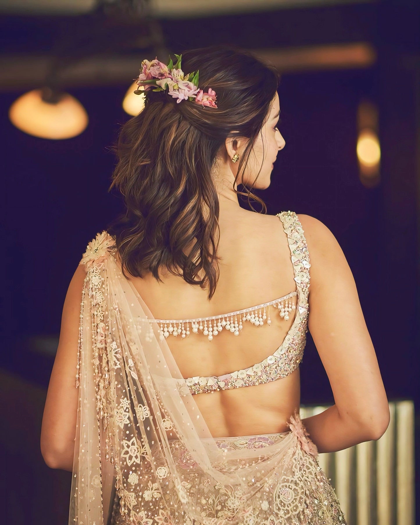 Ivory mirror work blouse with deep back design and pearl tassel detailing – celebrity-inspired ethnic fashion.