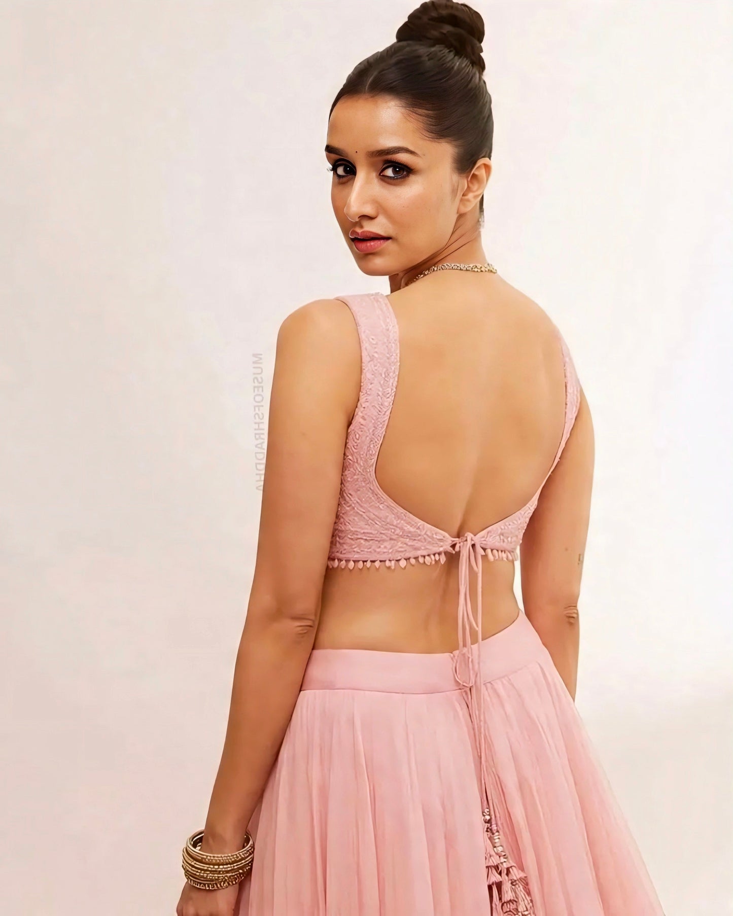 woman wearing a pastel pink backless lehenga choli with tie-back blouse and soft flared skirt