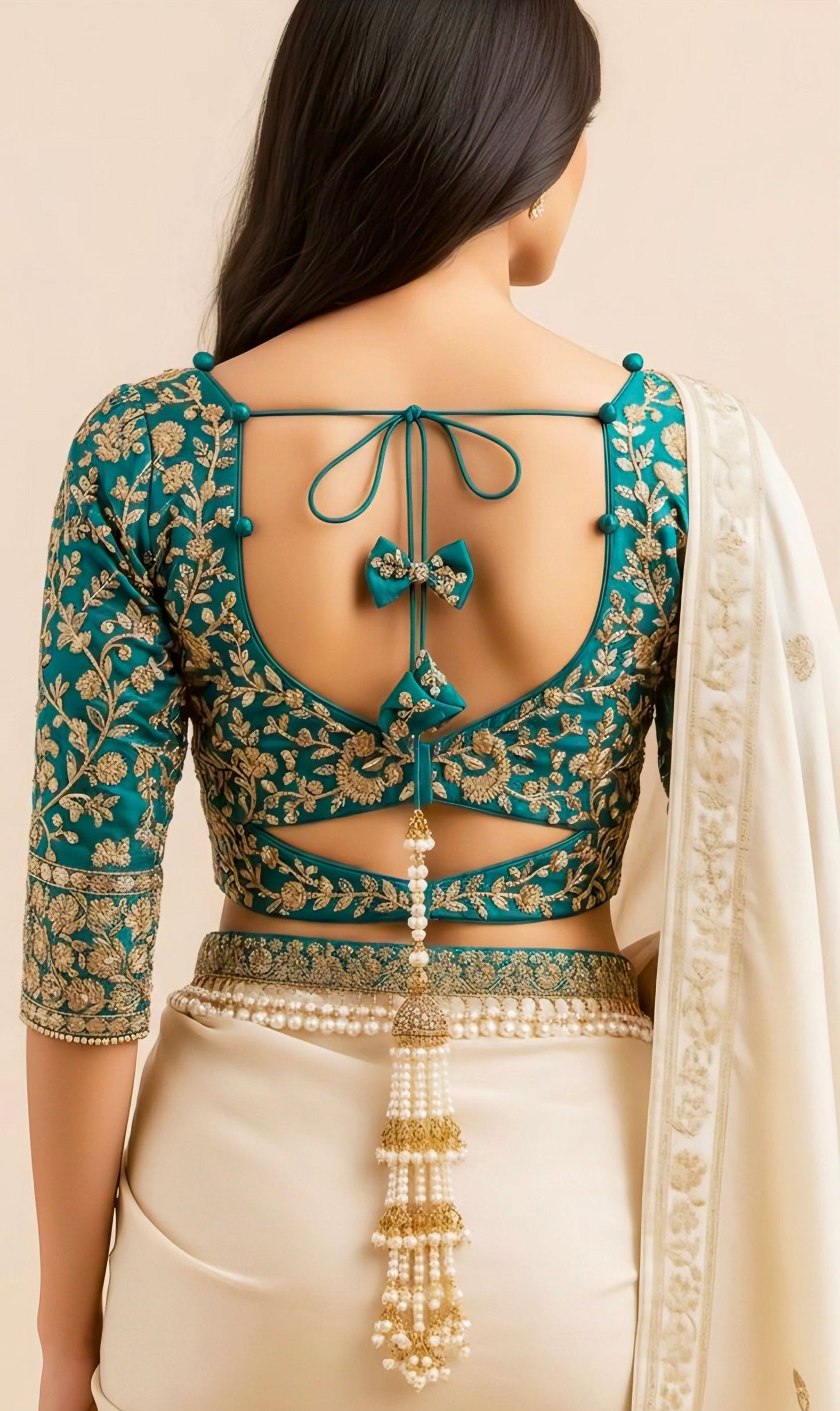 “Teal embroidered back-tie blouse design with golden zari work and pearl tassel detailing – blouse back side design inspiration.”