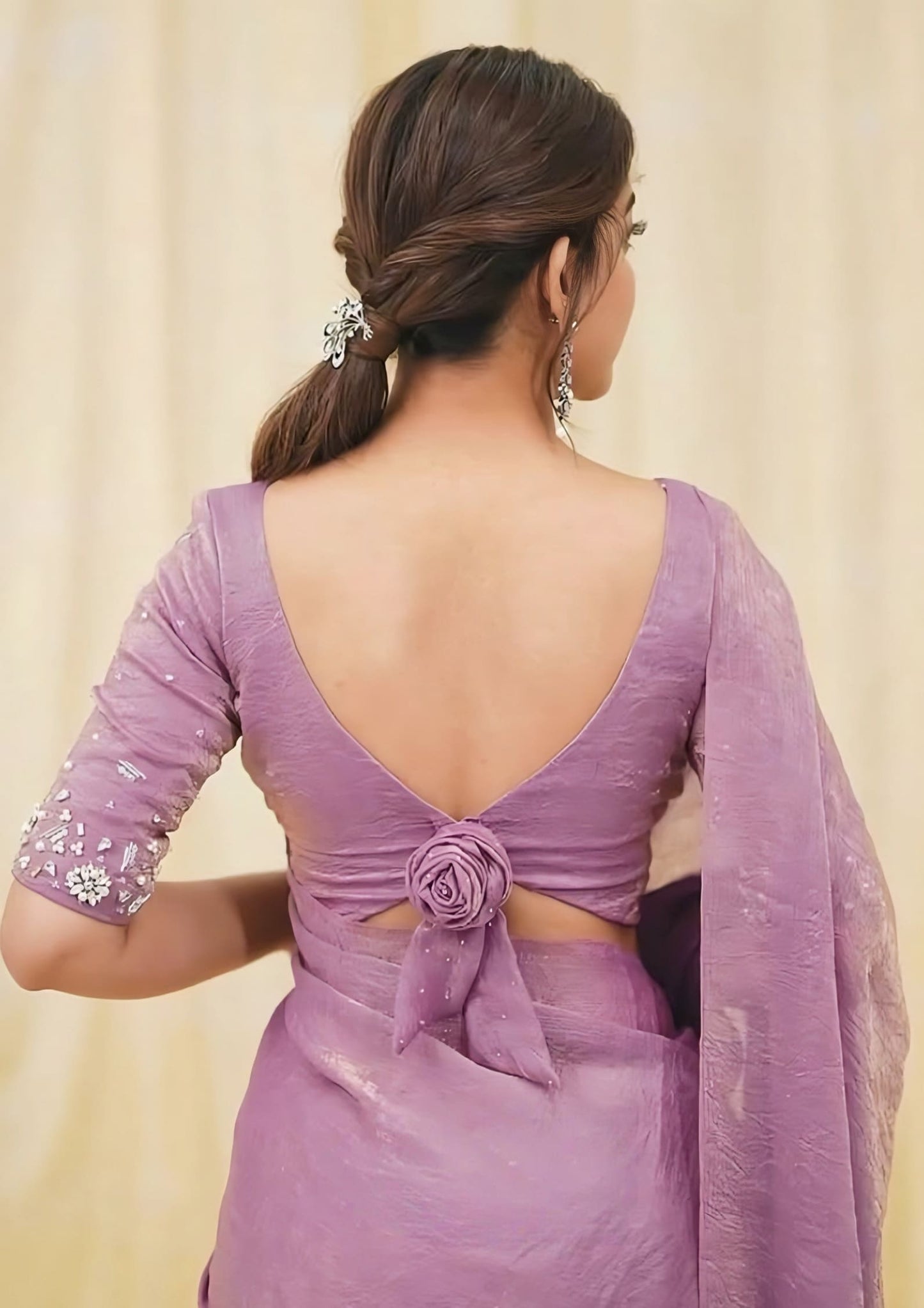 Elegant fancy blouse back design featuring deep V neckline with decorative rose knot paired with purple saree