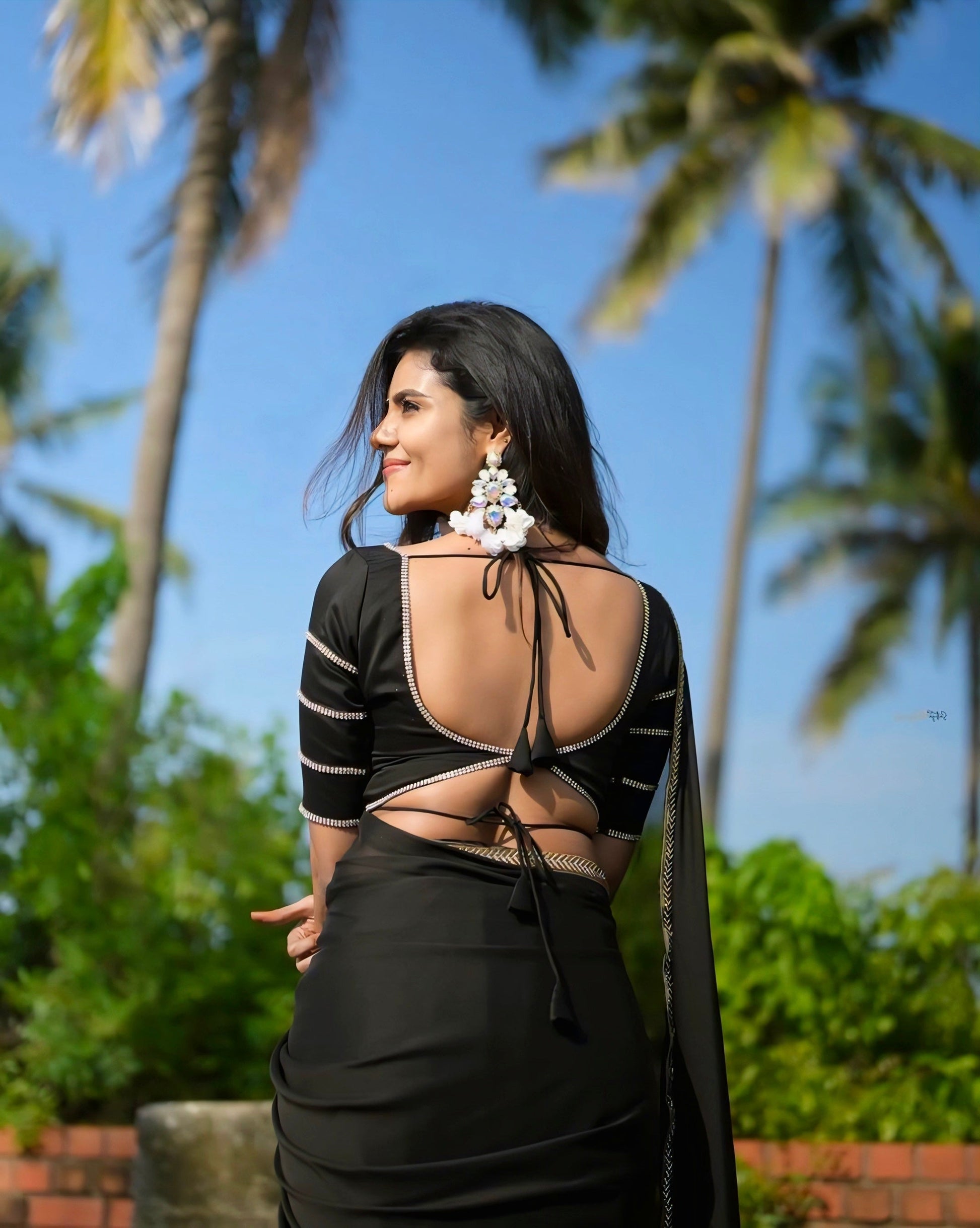 Elegant black deep-back blouse with double tie design and silver border, perfect for party and saree looks.