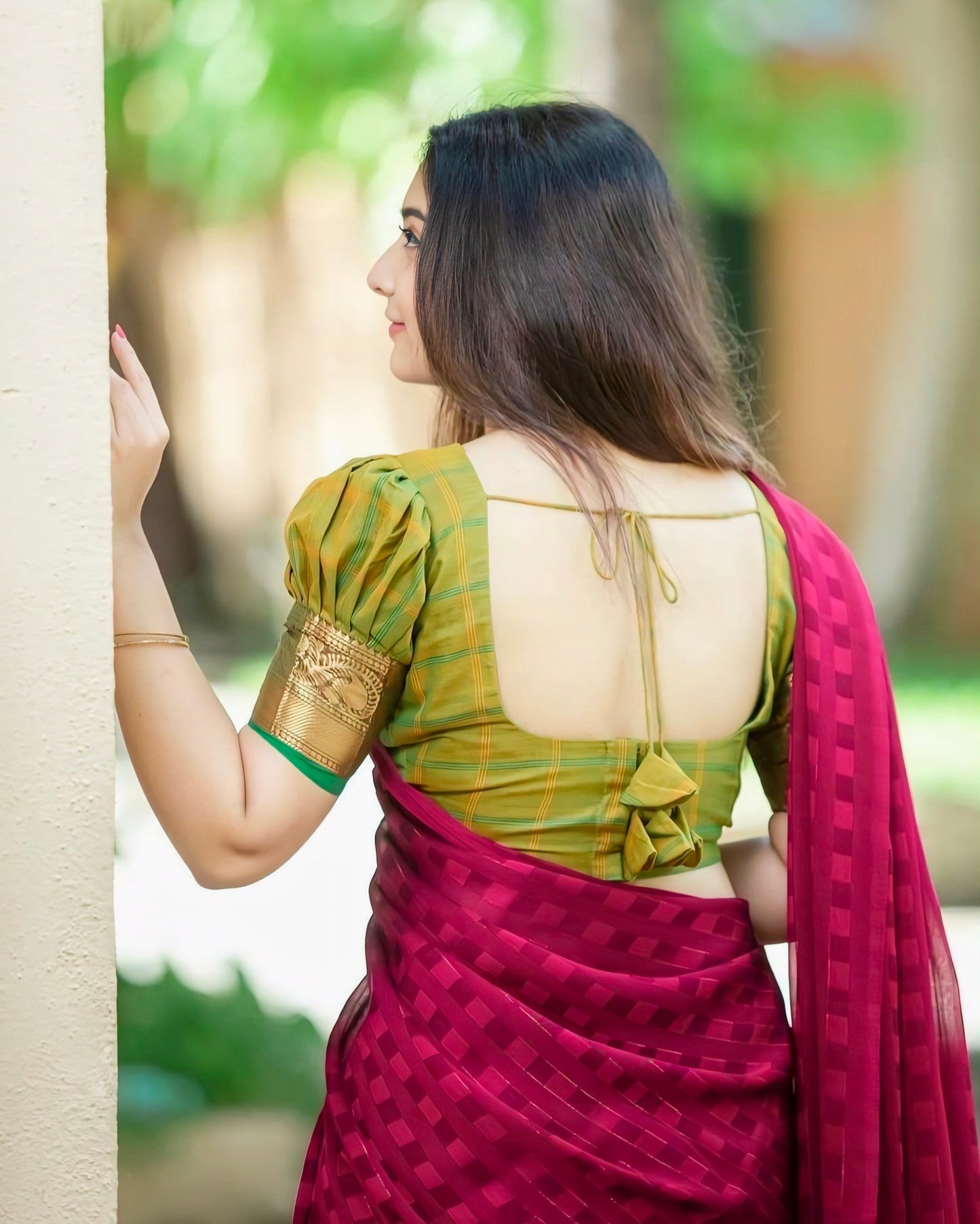 Green checked puff-sleeve blouse with back bow design paired with maroon saree.