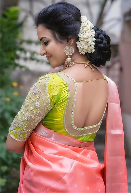 Lime green embroidered back neck blouse paired with peach silk saree, featuring pearl detailing and festive traditional design.