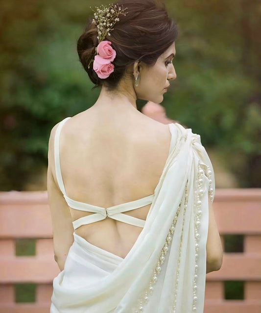 White saree blouse with elegant minimal cross-strap back design and pearl-embellished pallu