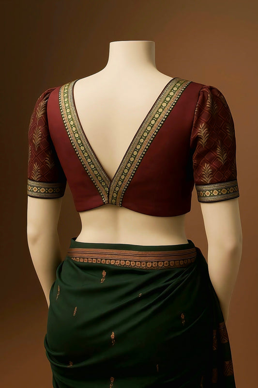 Maroon silk deep V-back blouse with gold and green zari border and designer sleeves.
