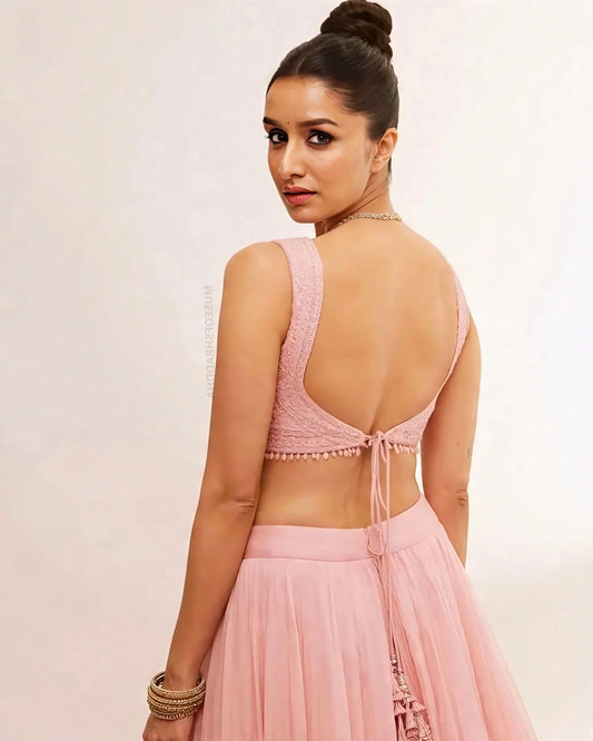 woman wearing a pastel pink backless lehenga choli with tie-back blouse and soft flared skirt