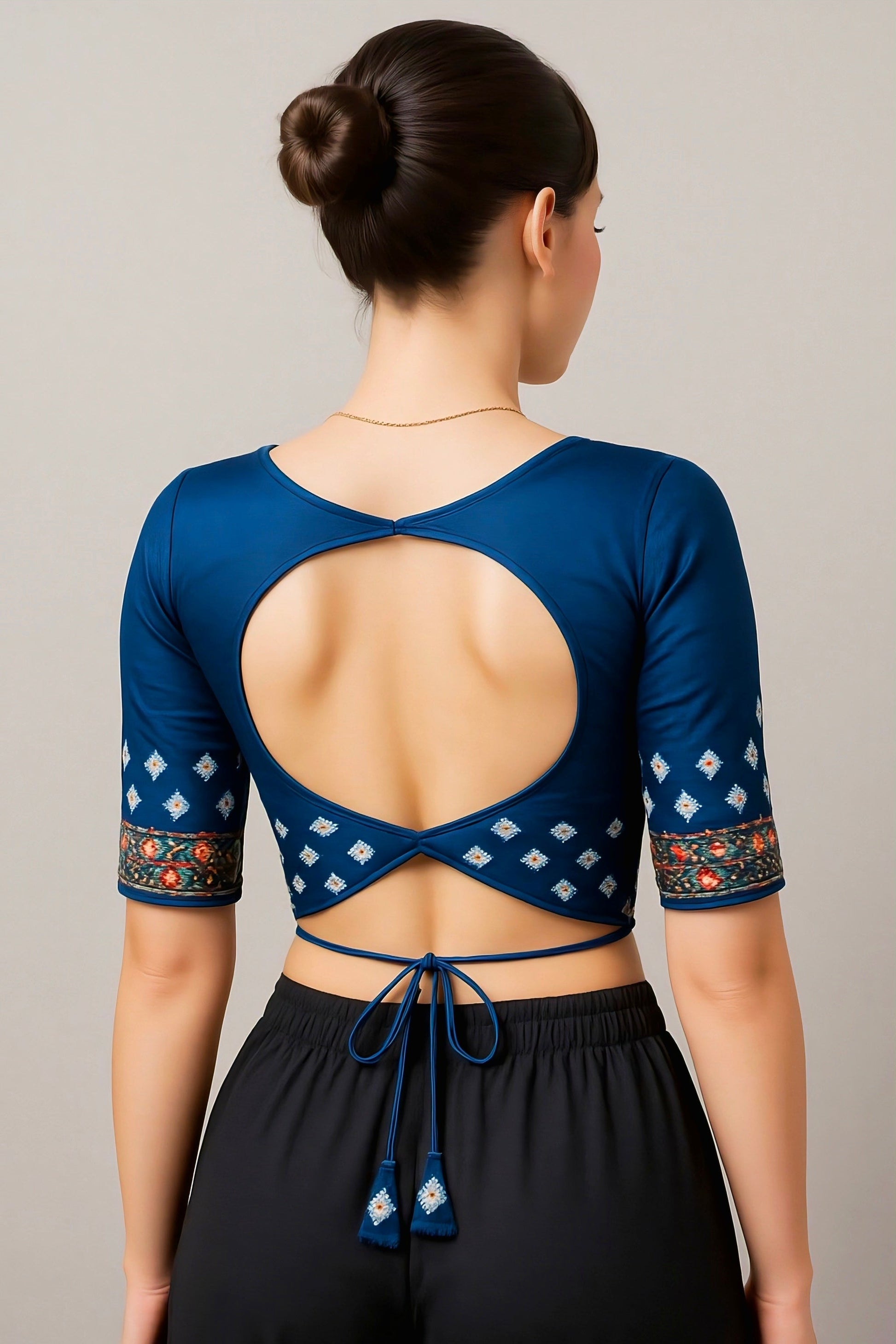 Blue back neck blouse with round cut-out design and embroidered sleeves featuring tie-back strings.