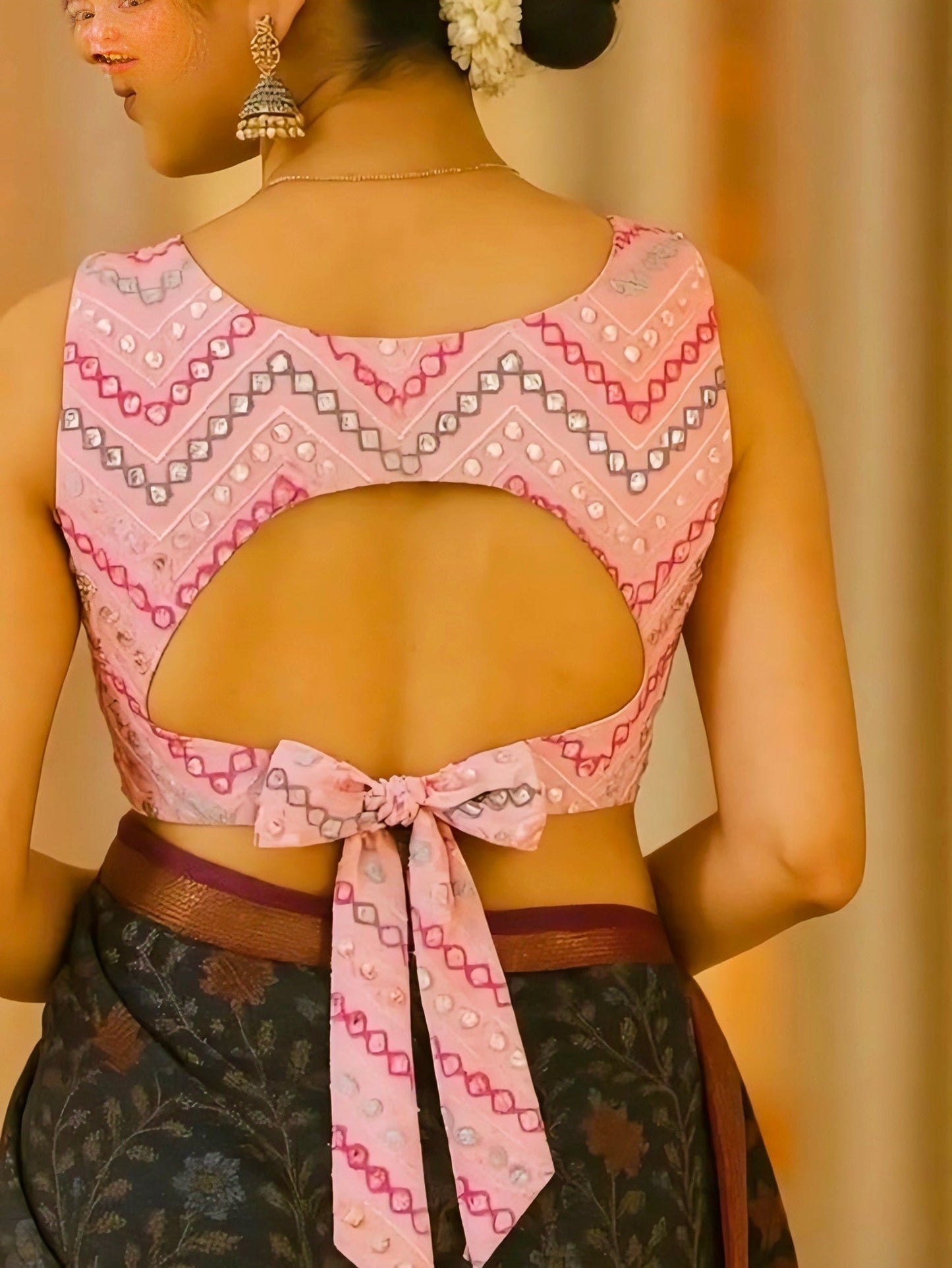 Pink sleeveless blouse with U-cut back neck design and long bow tie, decorated with geometric mirror-work pattern