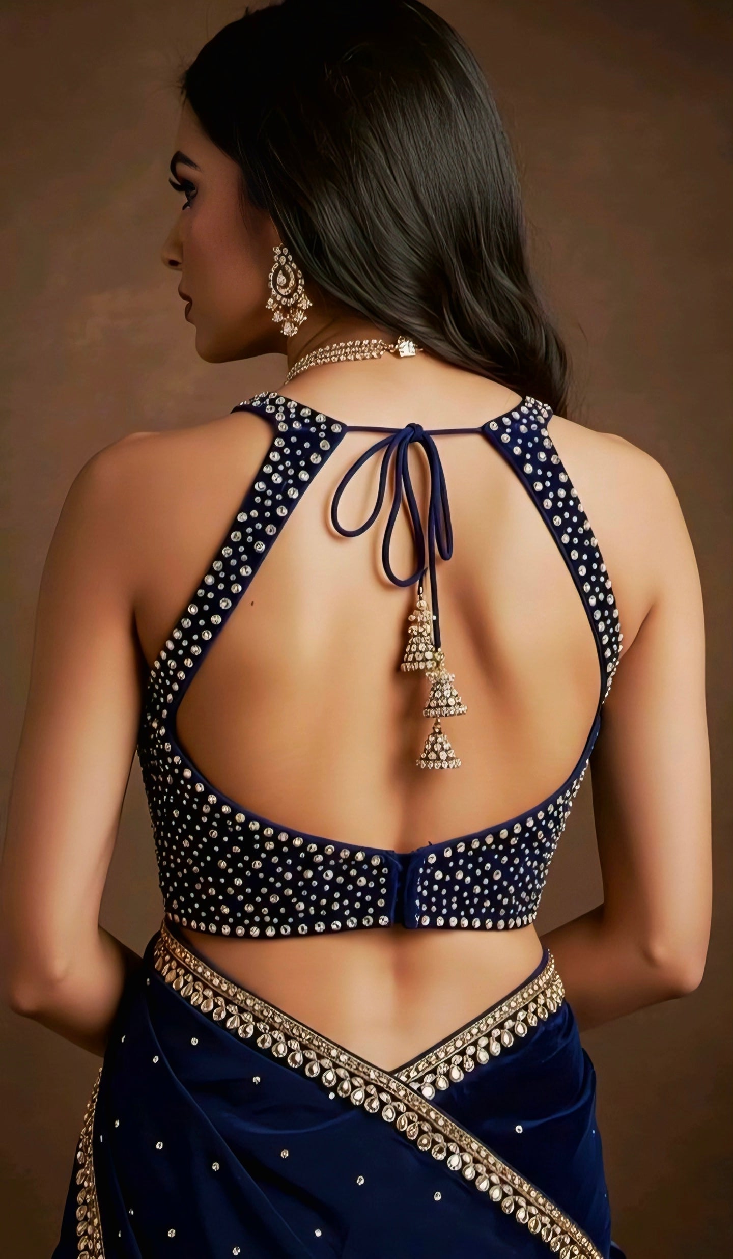 “Navy blue backless blouse with heavy stone work and halter tie-back design.”