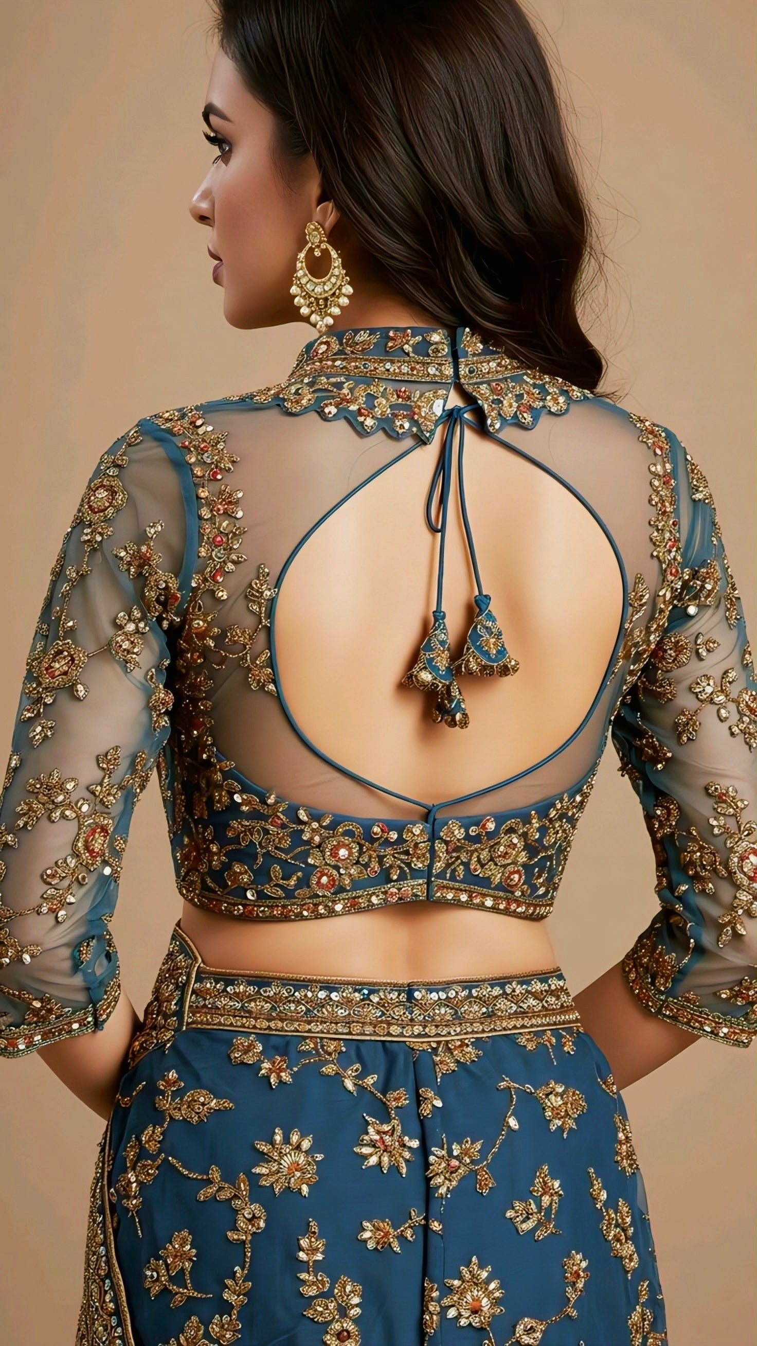 Woman wearing a blue embroidered sheer net blouse with round back cut and tassel tie-up, styled with matching embroidered lehenga.
