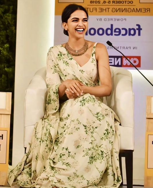 Woman wearing cream floral printed saree sitting and smiling