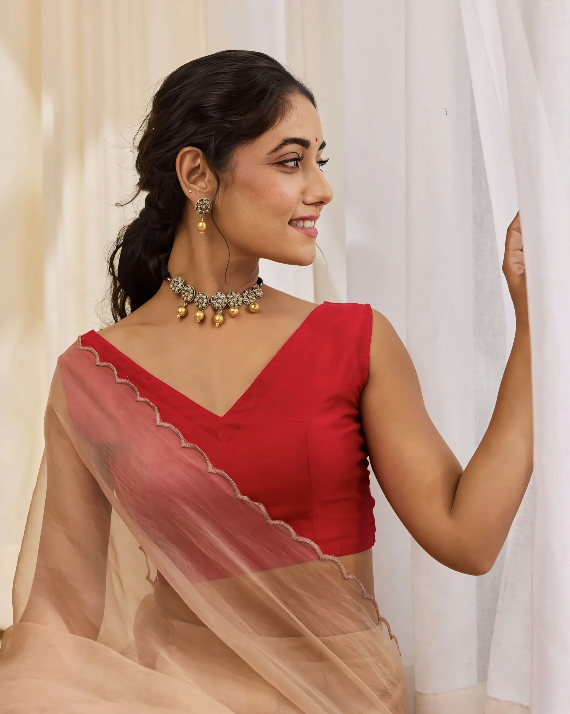 Deep red sleeveless silk blouse with elegant V-neckline for saree