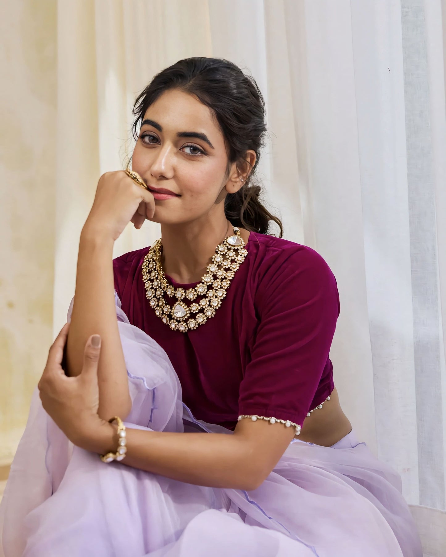 Wine purple round neck designer blouse with pearl embellished sleeves styled with pastel organza saree