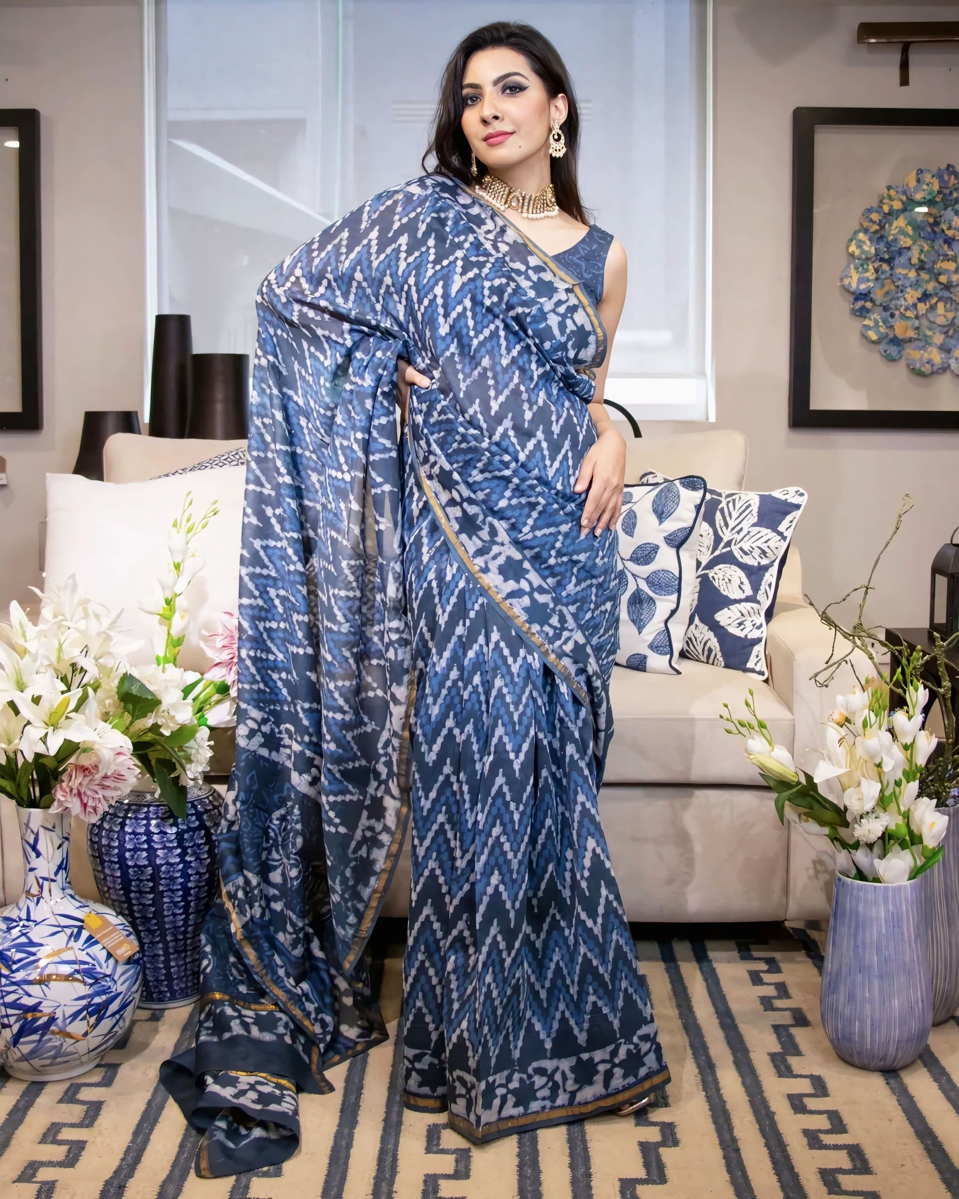 Blue ikat print sleeveless princess cut blouse paired with designer printed saree