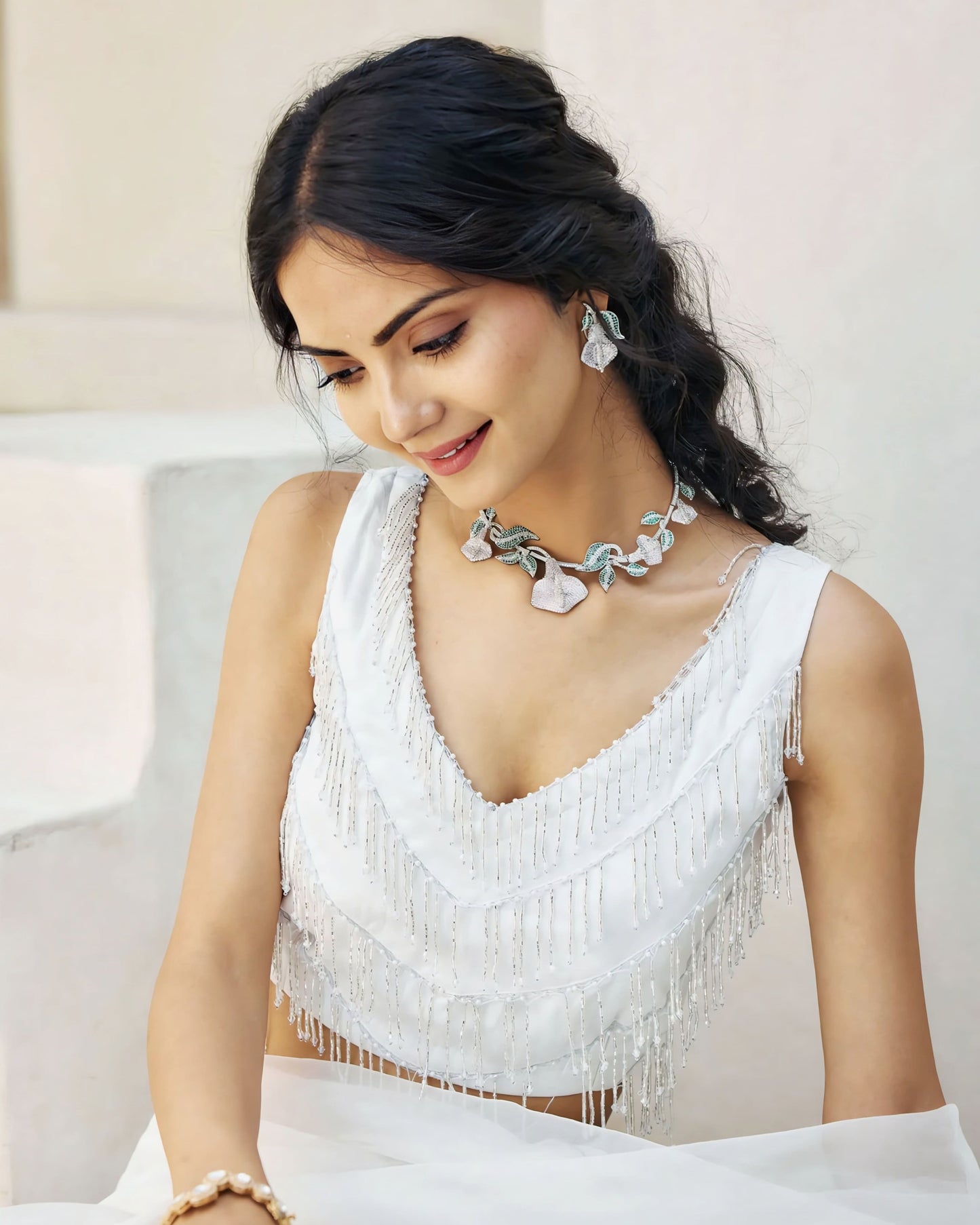 White sleeveless beaded princess cut blouse with V-neck paired with elegant saree