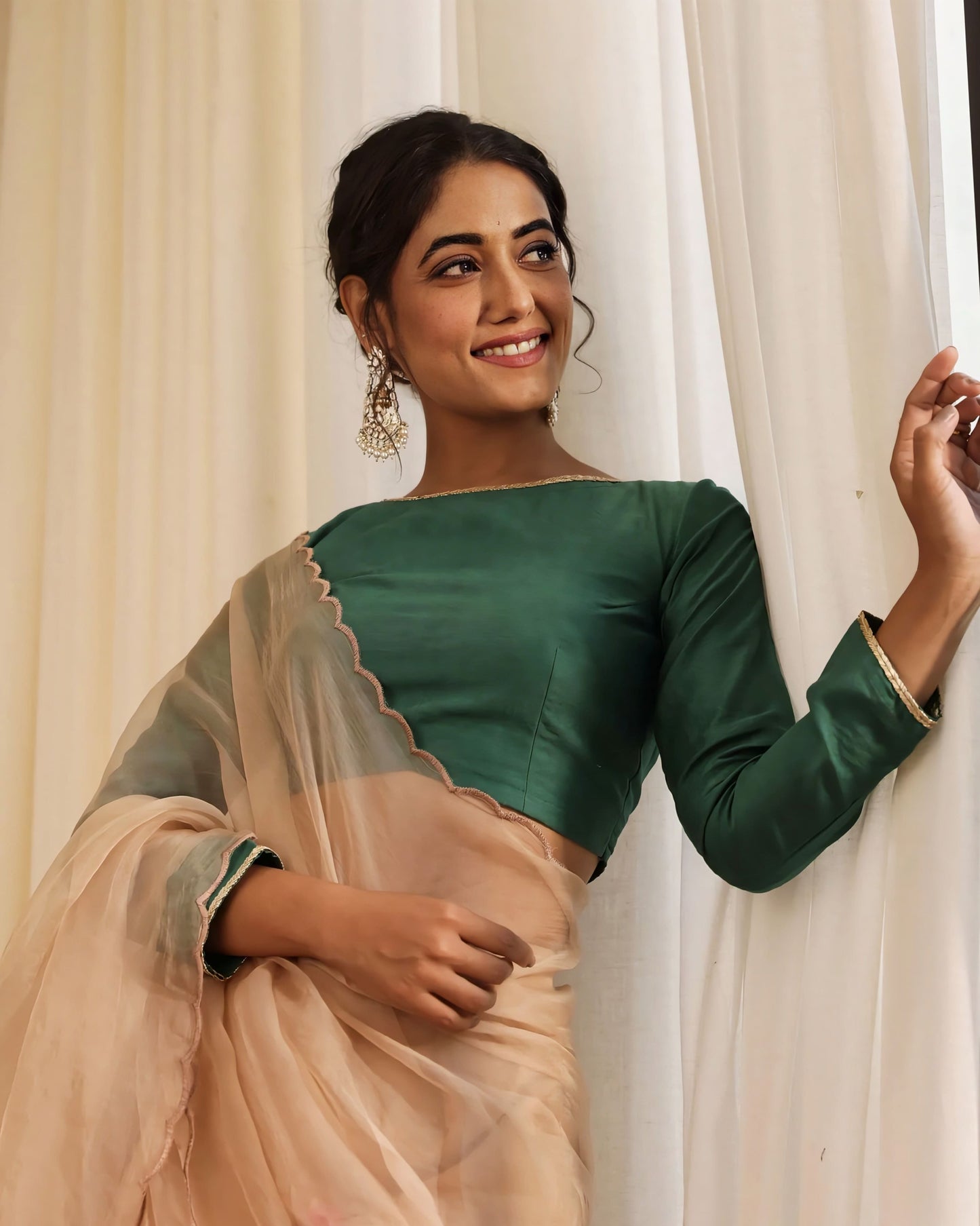 Bottle green long sleeve princess cut blouse with boat neck paired with sheer saree