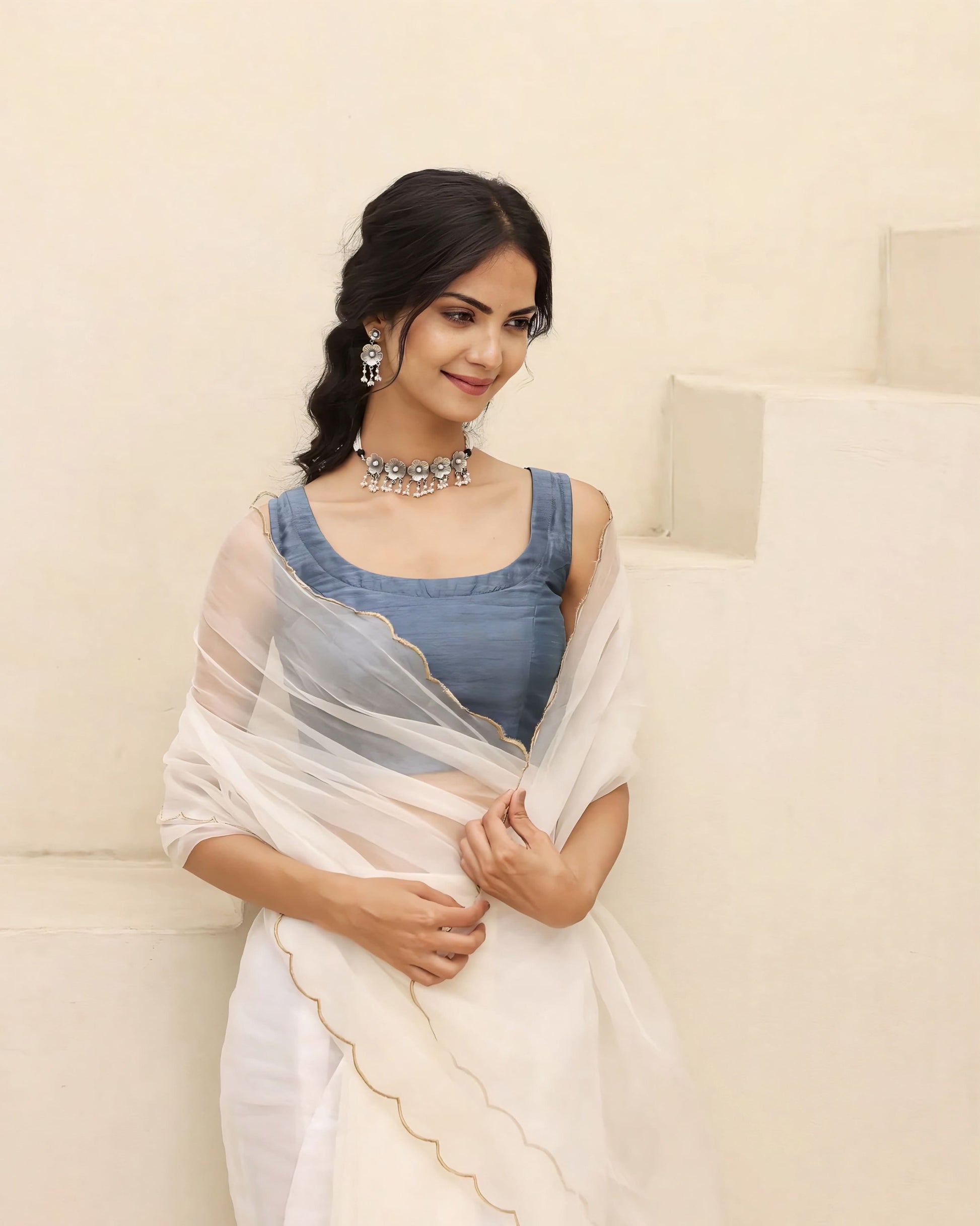 Steel blue princess cut sleeveless blouse with square scoop neckline paired with a sheer white saree