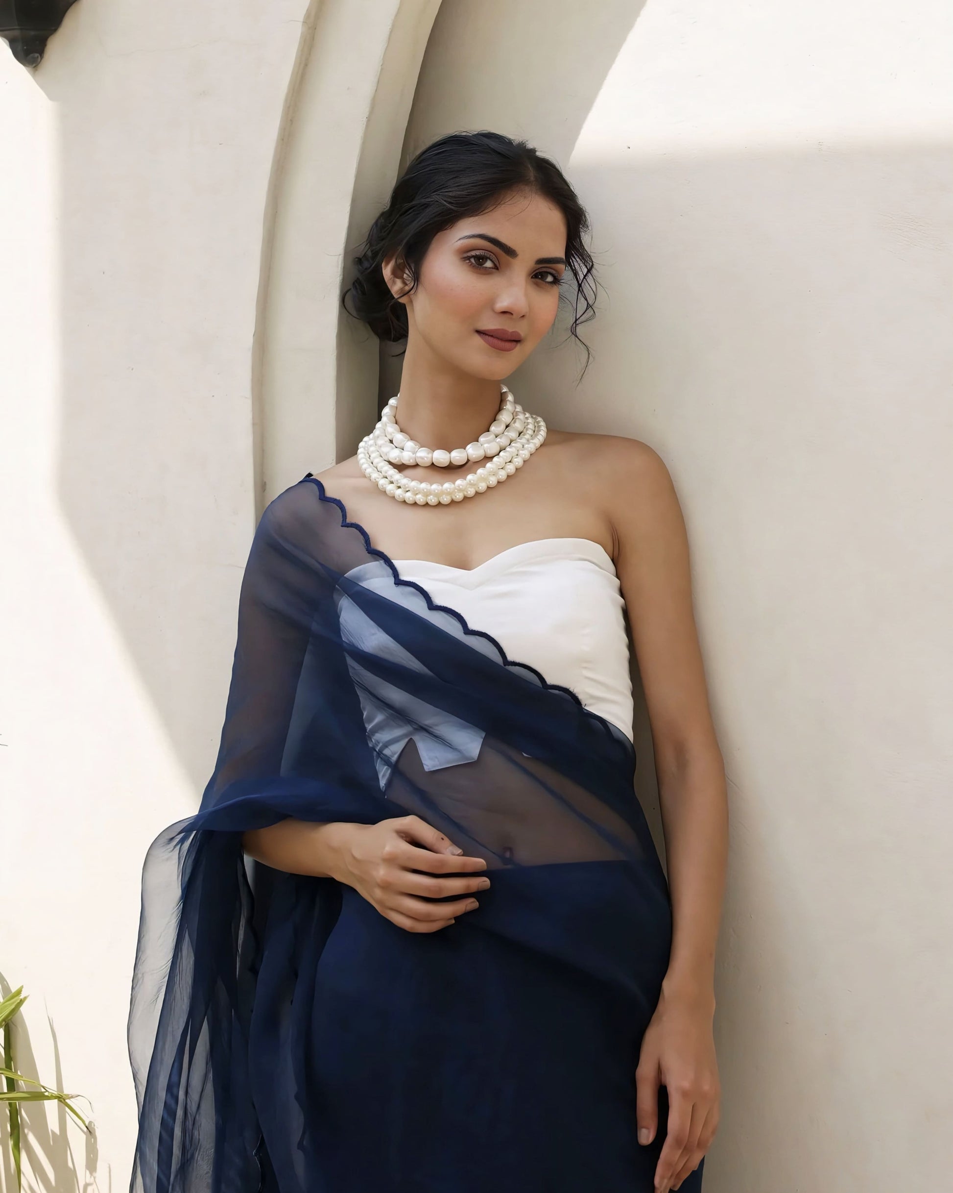 Ivory white princess cut strapless blouse with sweetheart neckline paired with a navy blue sheer saree