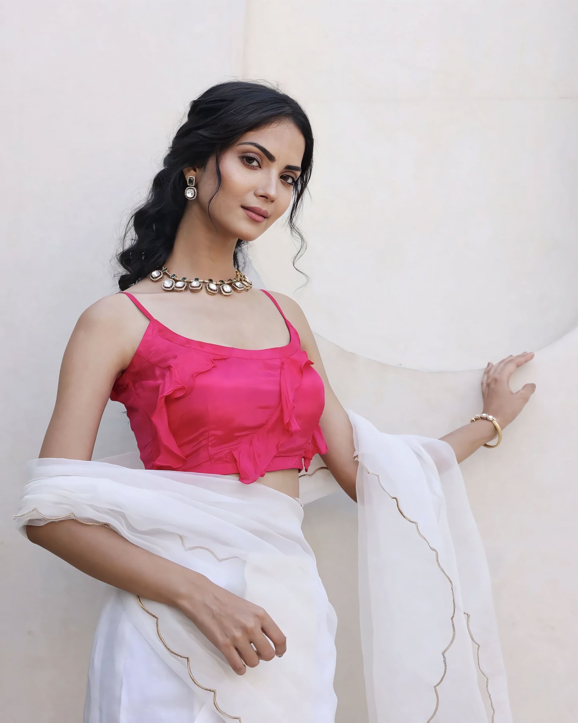 Fuchsia pink princess cut spaghetti strap blouse with scoop neckline paired with a white sheer saree