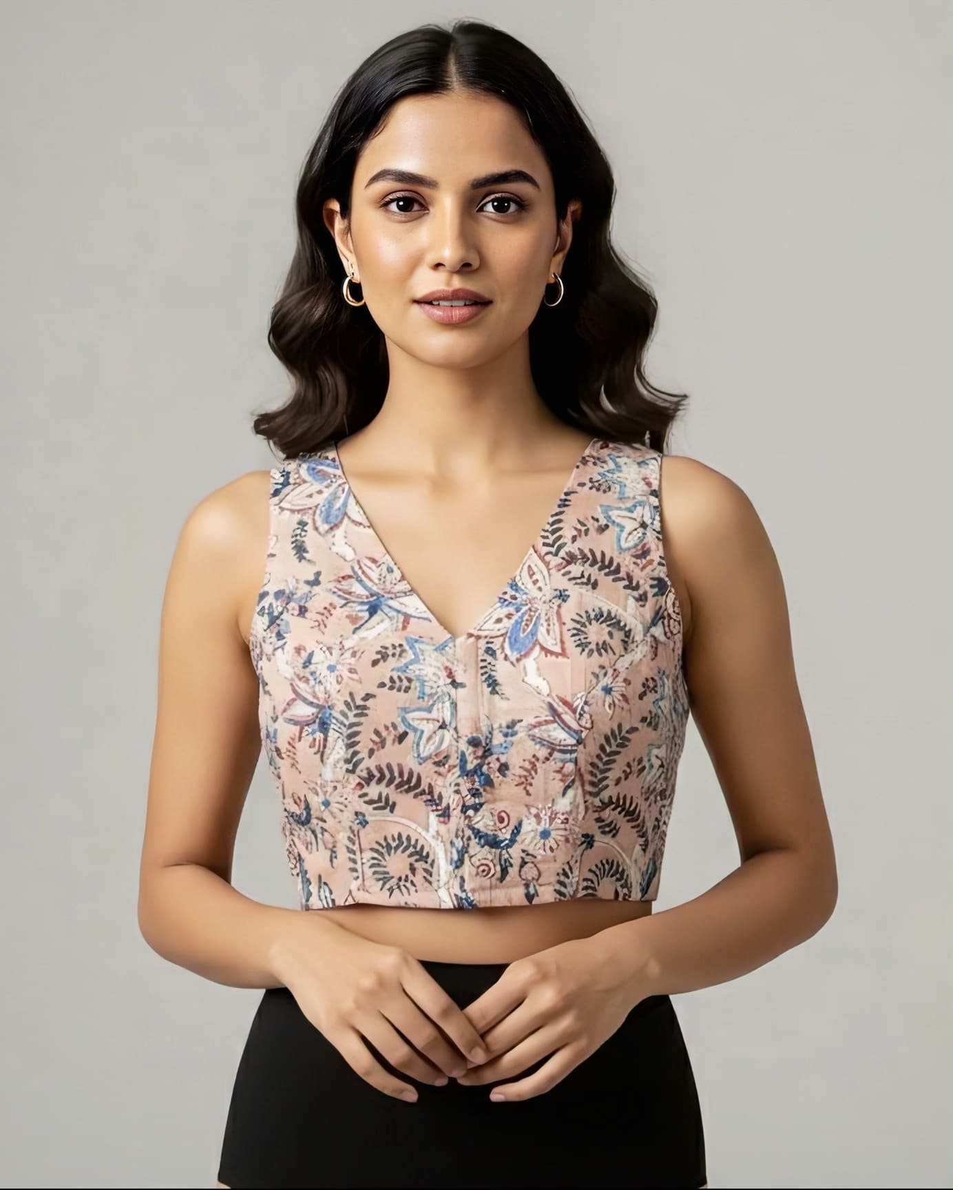 Beige floral fancy blouse design with sleeveless V neckline styled for wedding and festive saree wear.