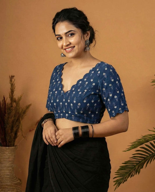 Navy blue printed fancy blouse design with scallop neckline paired with black saree.