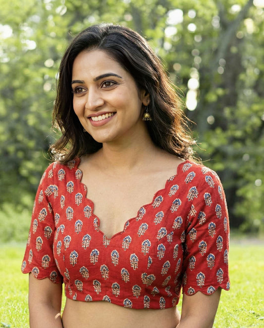 Red printed fancy blouse design with scallop neckline and half sleeves for festive saree styling.
