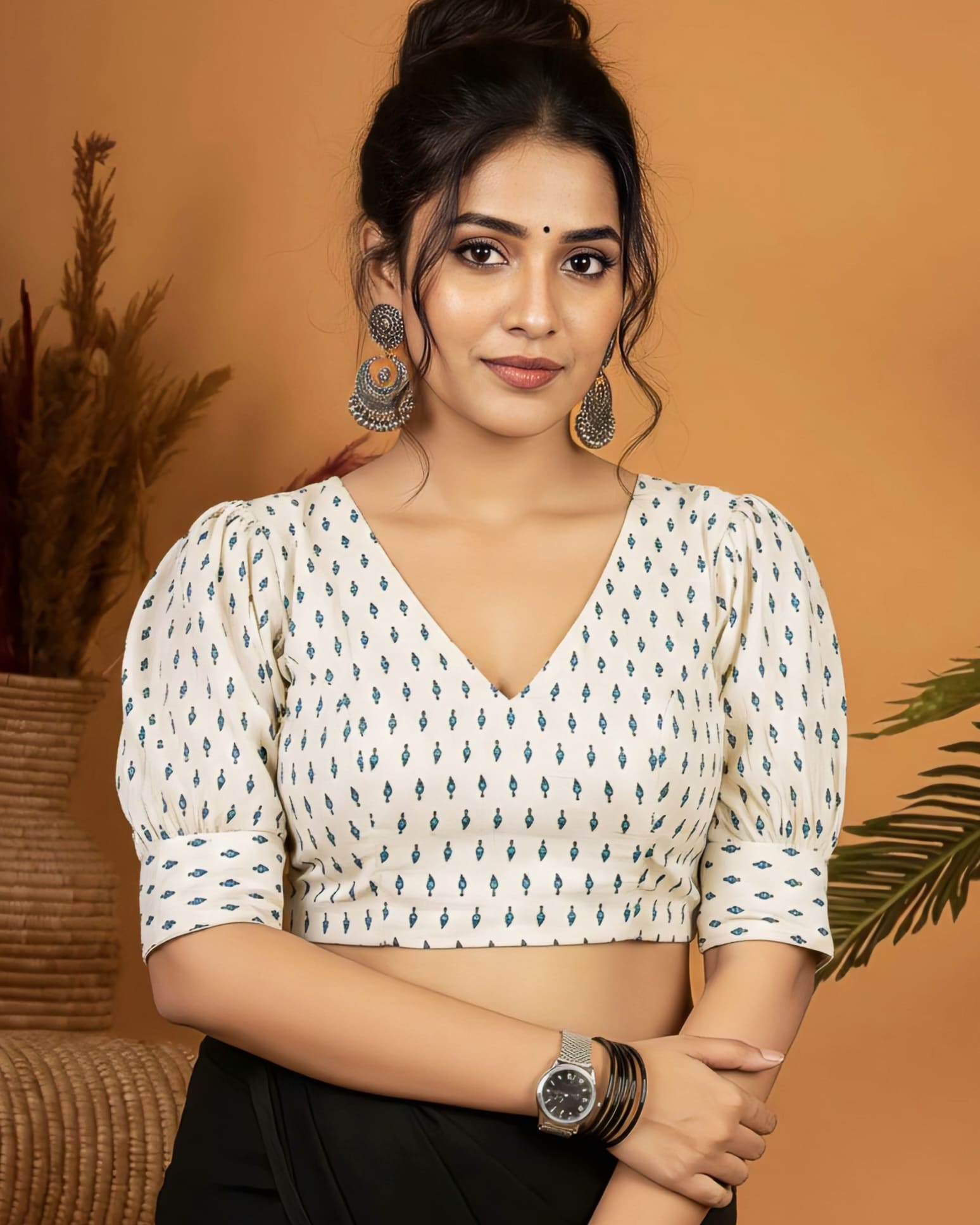 Ivory V neck printed blouse with puff sleeves styled with black saree.
