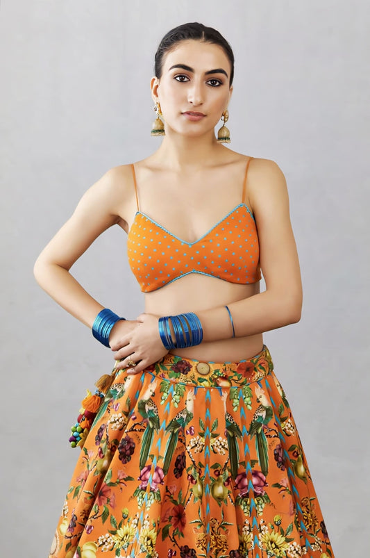 Orange polka dot printed fancy blouse design with contrast piping paired with printed skirt