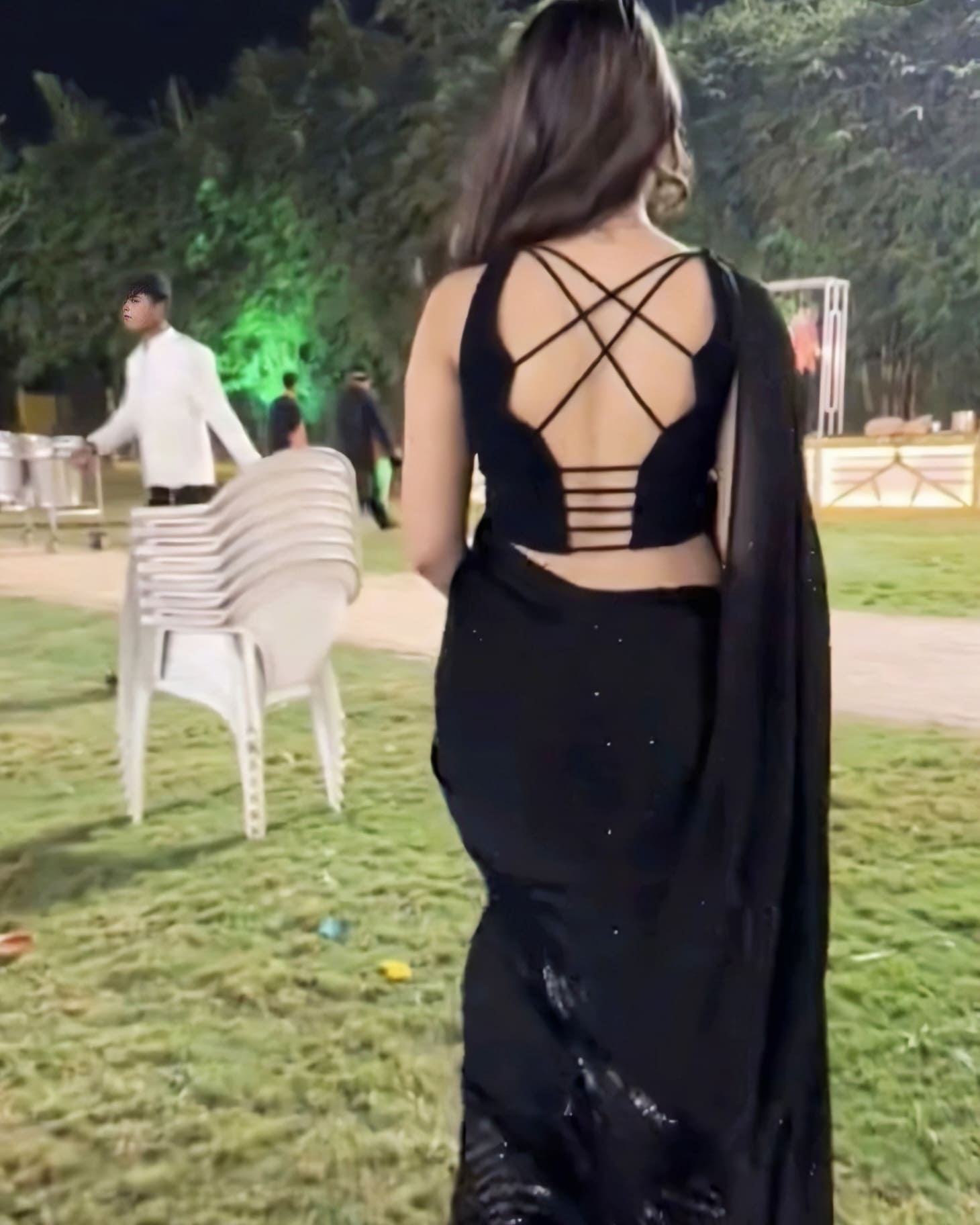 Trendy fancy blouse back design with criss-cross straps and multi-strap lower back paired with black saree