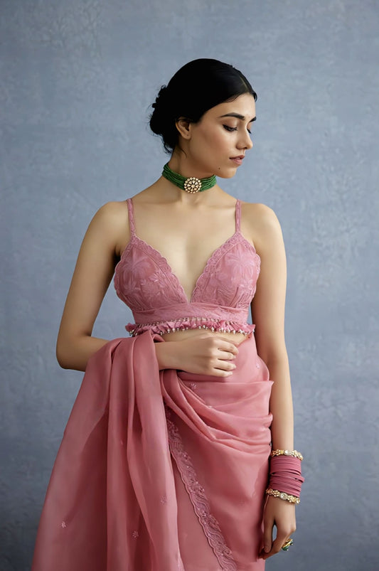 Pink embroidered fancy blouse design with tassels and deep neckline paired with saree