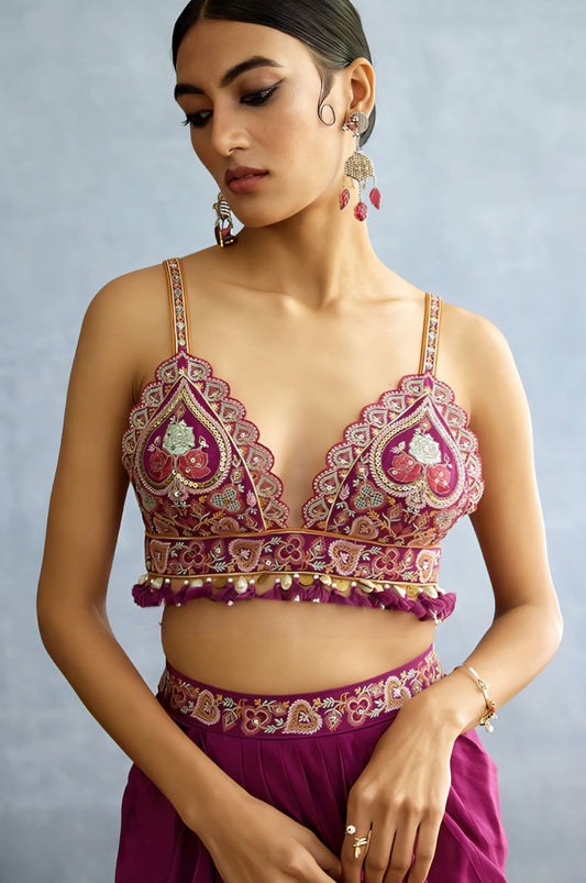Rani pink heavy embroidered blouse with tassels and deep neckline for bridal wear