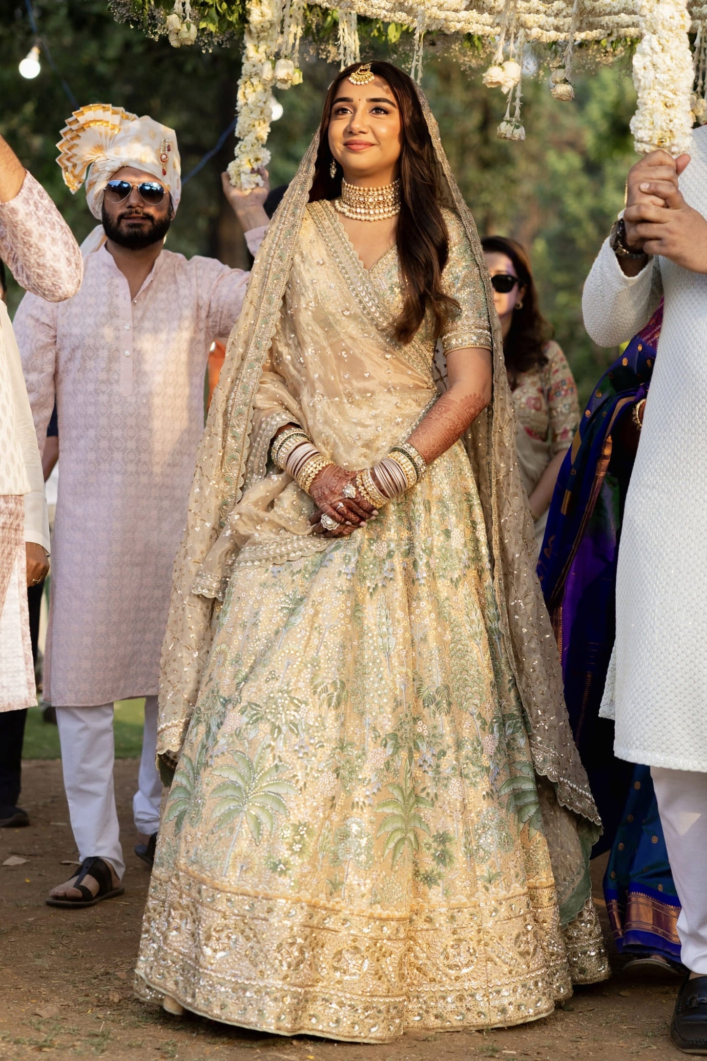 Prajakta Koli inspired gold silk lehenga with hand painted Pichhwai art and Parijat floral motifs with embroidered kalis for bridal wear