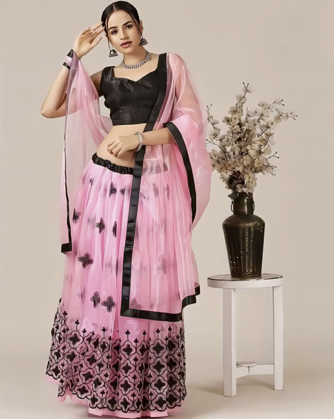 Woman wearing black embroidered blouse with pink lehenga choli set for wedding, festive, and party wear ethnic fashion.