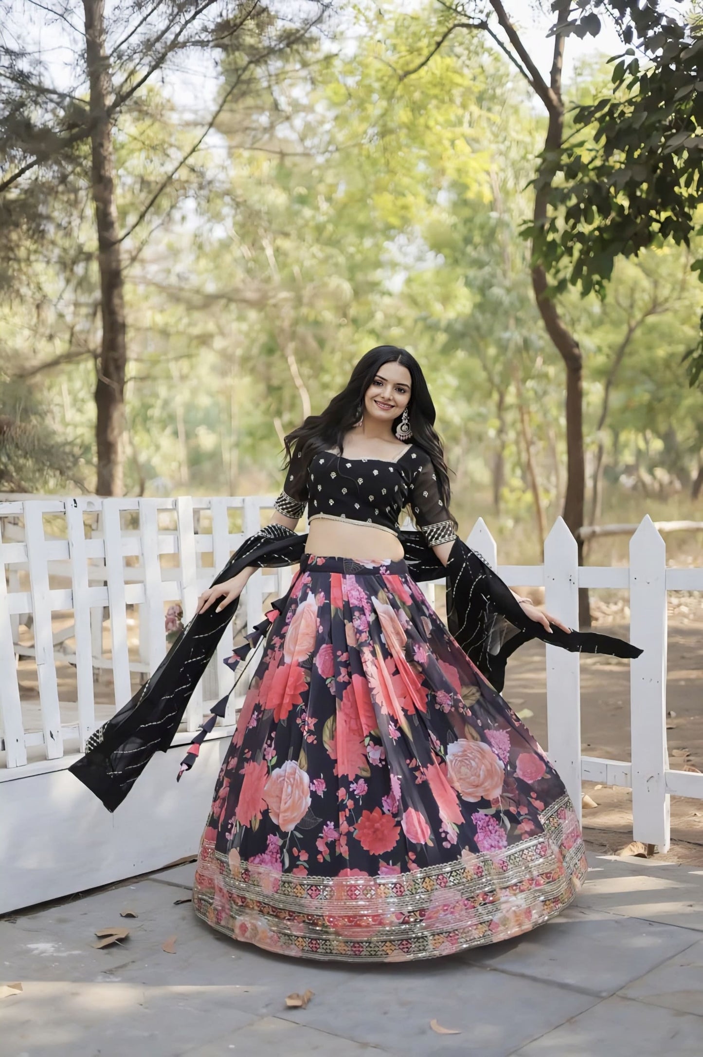 Woman wearing black blouse with floral pink lehenga and black dupatta for wedding, festive, Navratri, and party wear ethnic fashion.