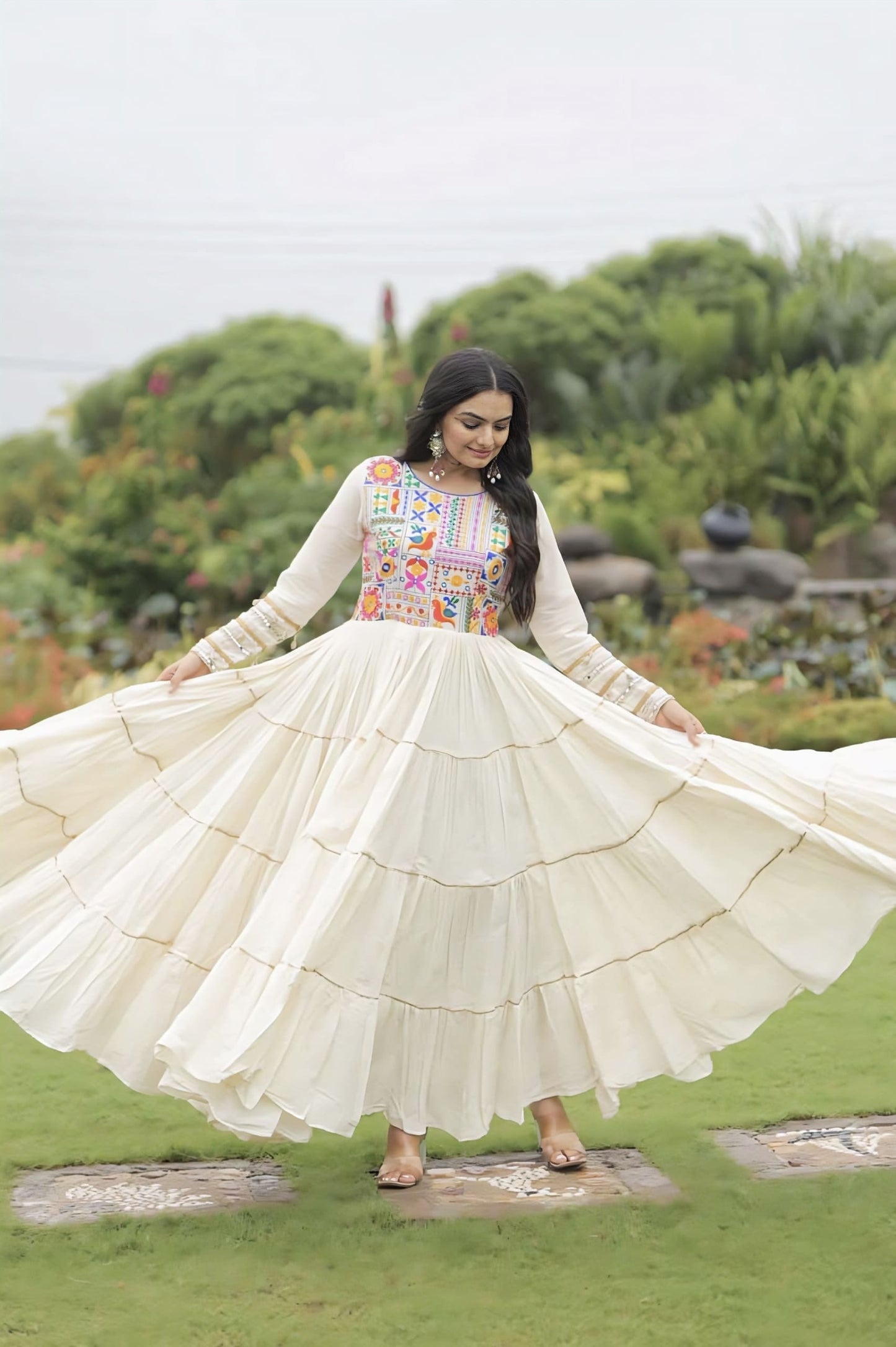 Off-white Kora cotton gown with multicolor thread embroidery, gota patti embellishments, full sleeves, and cotton lining for festive and ethnic wear