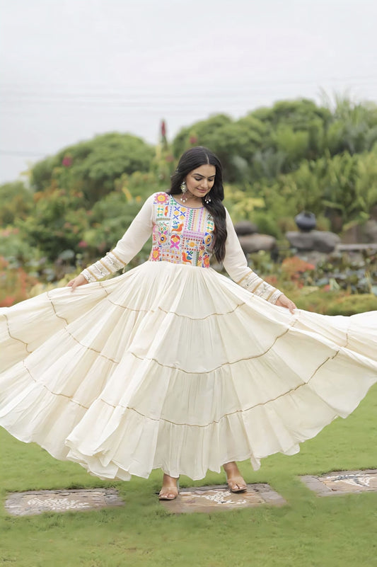 Off-white Kora cotton gown with multicolor thread embroidery, gota patti embellishments, full sleeves, and cotton lining for festive and ethnic wear