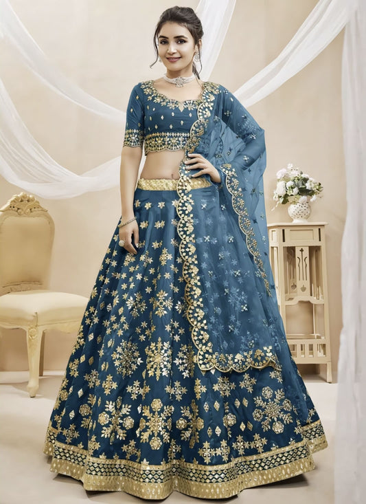 Teal blue mulberry silk lehenga choli with foil mirror work, zari embroidery, matching blouse, and net dupatta for wedding and festive wear